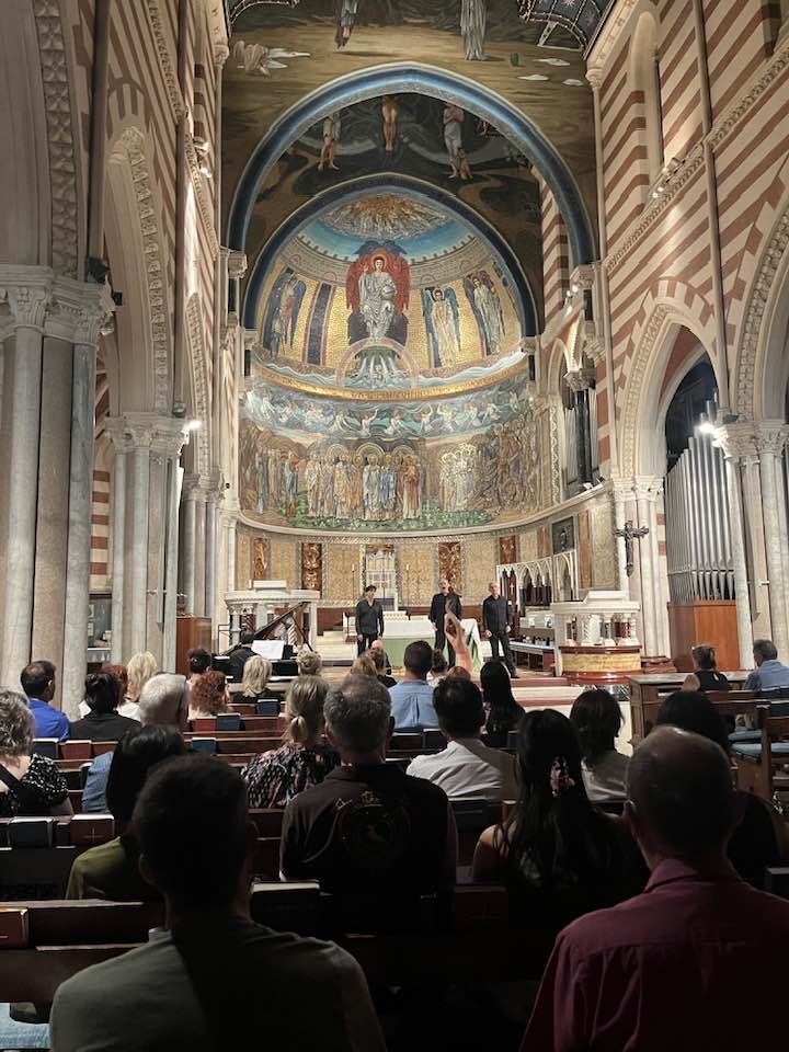 Tónleikar þriggja tenóra í kirkju í Róm, mynd tekin úr sal. Tenórarnir standa við altarið.