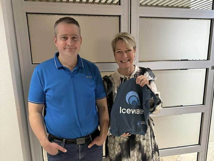 Sigríður með Sæmundi við starfsmannainnganginn að stjórnsýslu- og fjármálasviði. Sigga heldur á taupoka sem á stendur Icewater.