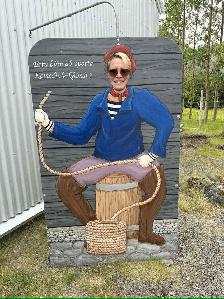 Sigga í ljósmyndaspjaldi Kómedíuleikhússins, sem er máluð mynd af manneskju sem situr á tunnu með stóran kaðalvöndul fyrir framan sig. Á spjaldinu stendur textinn "Ertu búin að spotta Kómedíuleikhúsið?"