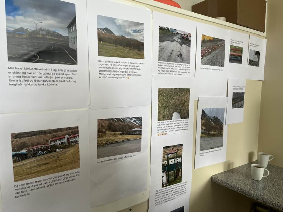 Kynningar á hugmyndum nemenda prentaðar út og hengdar upp á vegg.