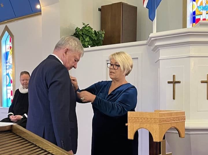 Lilja Rafney afhendir Guðna Einars heiðursorðu sjómannadagsins í Suðureyrarkirkju.