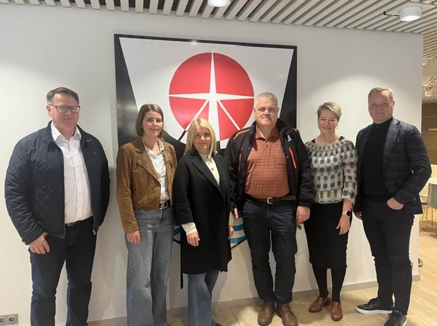 Fundarfólk frá Ísafjarðarbæ og Eimskip stilla sér upp fyrir framan merki Ísafjarðarbæjar í afgreiðslu sveitarfélagsins í Stjórnsýsluhúsinu.