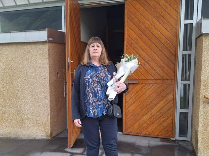 Ágústa fyrir utan Ísafjarðarkirkju með blómvönd í fanginu.