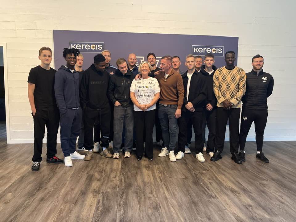 Hópmynd af Höllu Tómasdóttur og liðsmönnum knattspyrnuliðs Vestra í vallarhúsinu á Ísafirði.