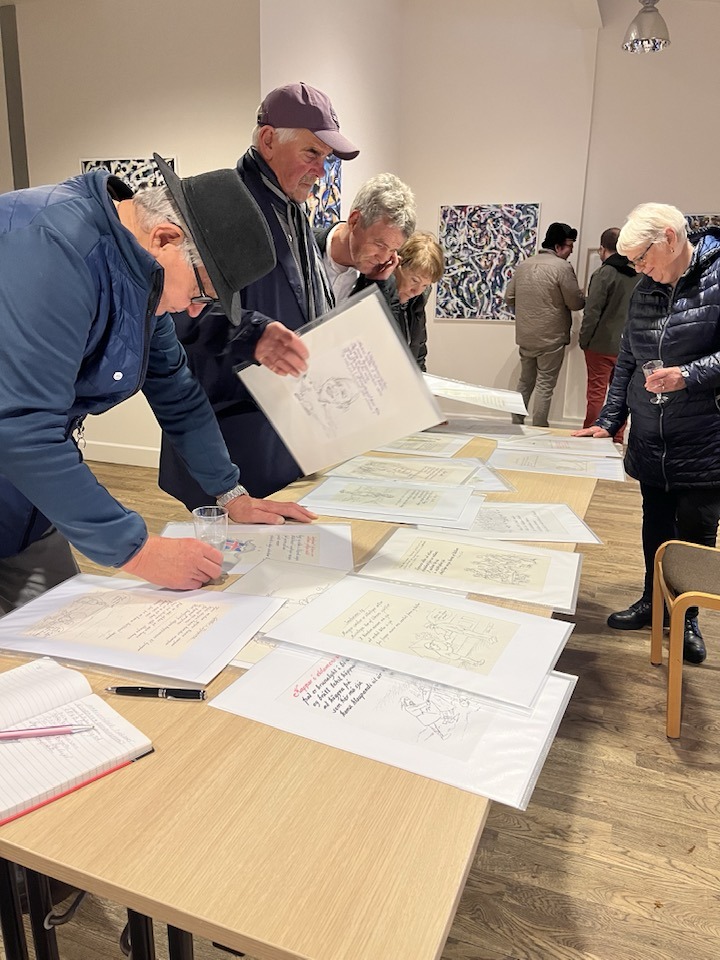 Gestir á opnuninni við borð með skissum og ljóðum eftir Pétur.