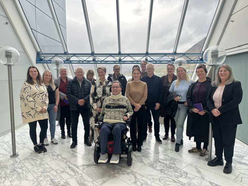 Hópmynd af þátttakendum á fundi Ísafjarðarbæjar og ÖBÍ. Hópurinn stendur í opnu rými í Stjórnsýsluhusinu, fyrir framan fundarsal bæjarstjórnar.