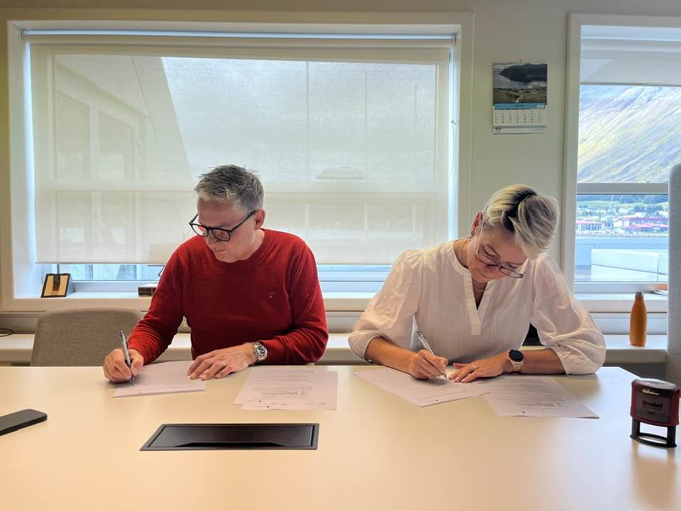 Þorleifur Björnsson og Sigga skrifa undir samning um hönnun nýrrar slökkvistöðvar við fundarborð á skrifstofu bæjarstjóra.