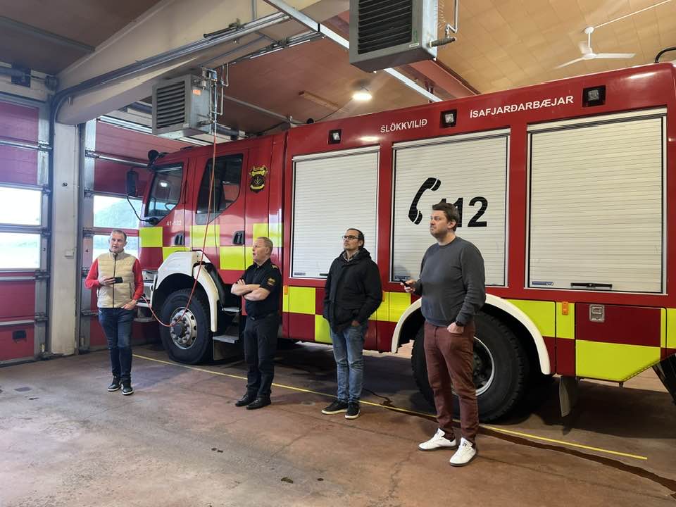 Fulltrúar hönnunarstofunnar, slökkviliðsins og Ísafjarðarbæjar við hlið slökkvibíls í gömlu slökkvistöðinni.