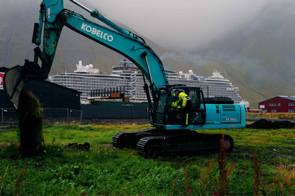 Túrkísblá grafa tekin til kostana á lóð nýrrar slökkvistöðvar.