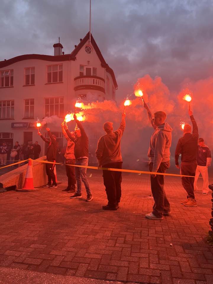 Kveikt á rauðum blysum á Silfurtorgi.