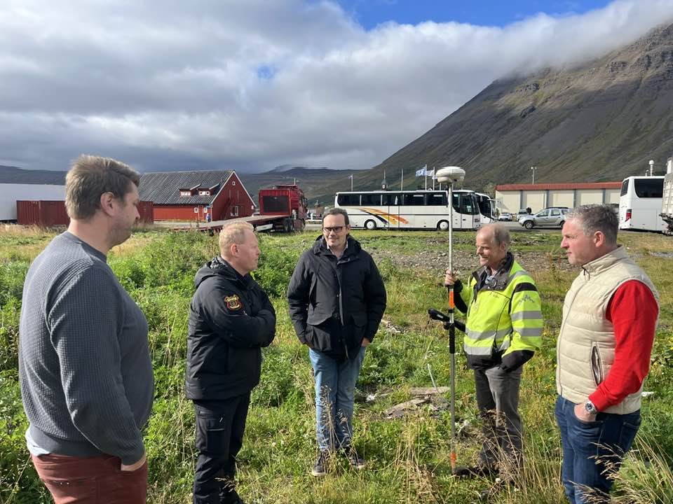 Fulltrúar Ísafjarðarbæjar, slökkviliðs, Verkís og hönnunarstofunnar á lóð nýrrar slökkvistöðvar á Suðurtanga. Í baksýn er Neðstikaupstaður.