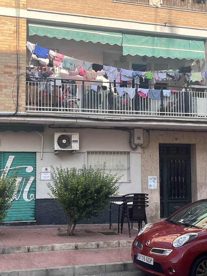 Svalir á annarri hæð þar sem þvottur hangir til þerris.