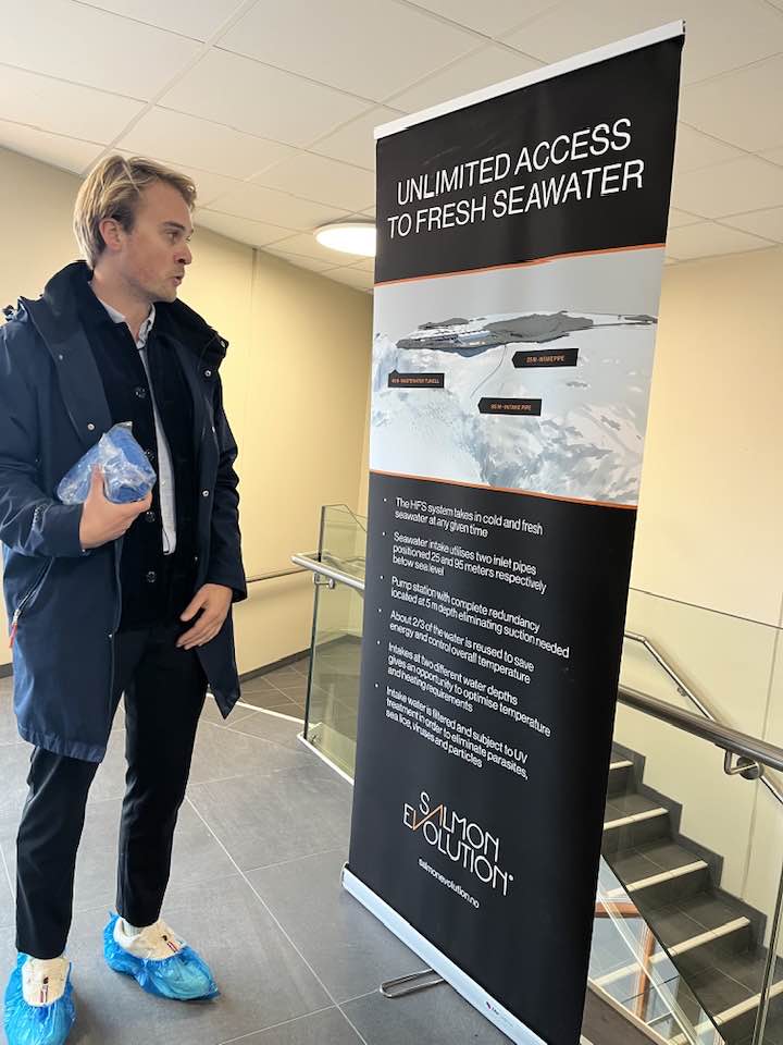 Maður stendur við upplýsingaspjald um landeldi.