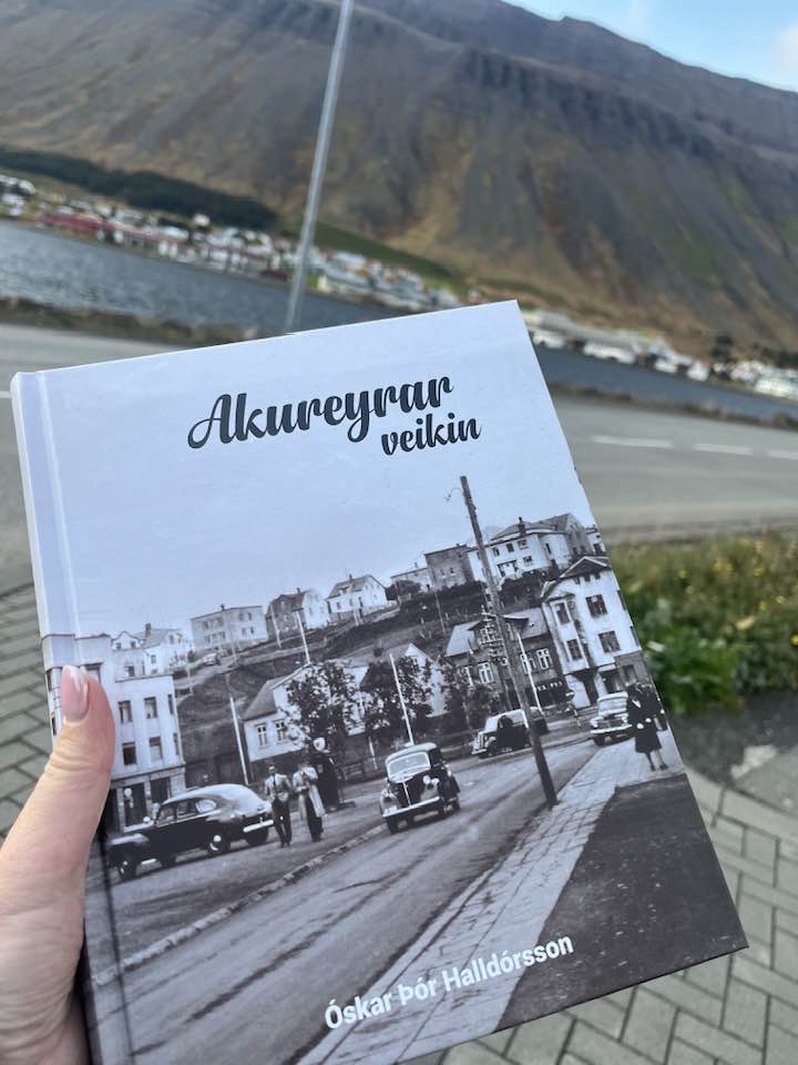 Bókin Akureyrarveikin, mynd tekin úti við Pollgötuna á Ísafirði.