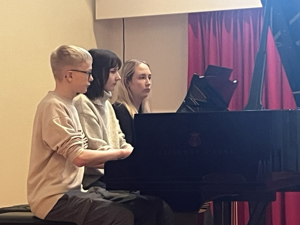 Þrír nemendur TÍ spila sexhent á flygilinn í Hömrum.