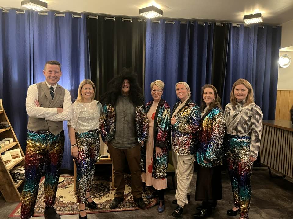 Fulltrúar Ísafjarðarbæjar á fjórðungsþinginu íklæddir pallíettugöllum. Þau hafa stillt sér upp í anddyri félagsheimilisins.