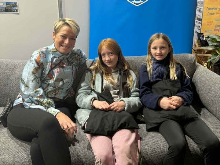 Sigga í sófanum í bás Ísafjarðarbæjar á Gullkistunni, með tveimur ungum stúlkum.