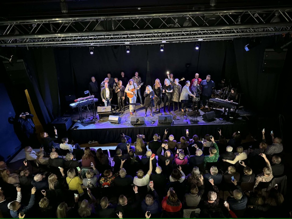 Séð niður í salinn í Edinborgarhúsinu ofan af svölum. Sviðið er fullt af tónlistarfólki og úti í sal eru margir áhorfendur.