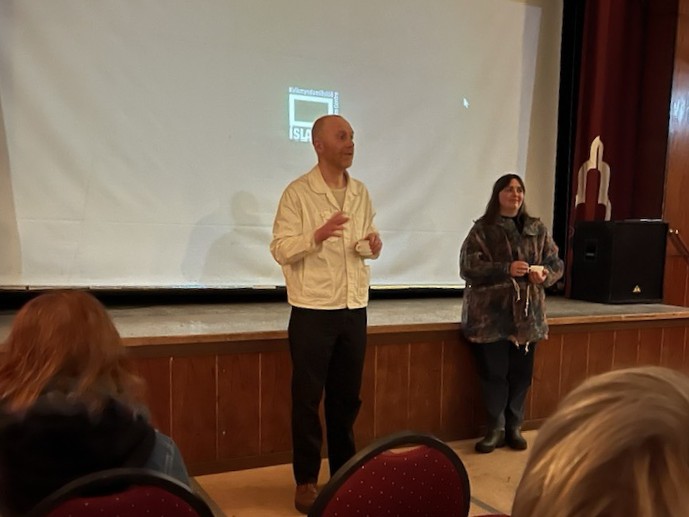 Aðstandendur kvikmyndarinnar Paradís Amatörsins fyrir framan bíódúk í félagsheimilinu á Þingeyri.