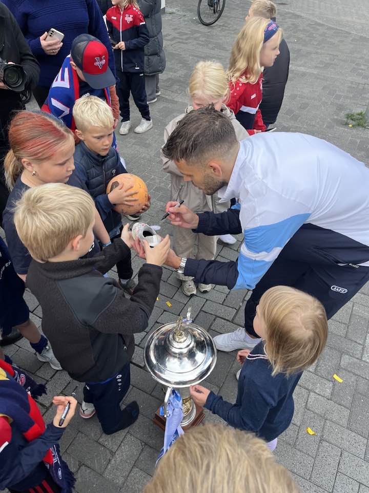 Leikmaður Vestra gefur börnum eiginhandaráritanir.