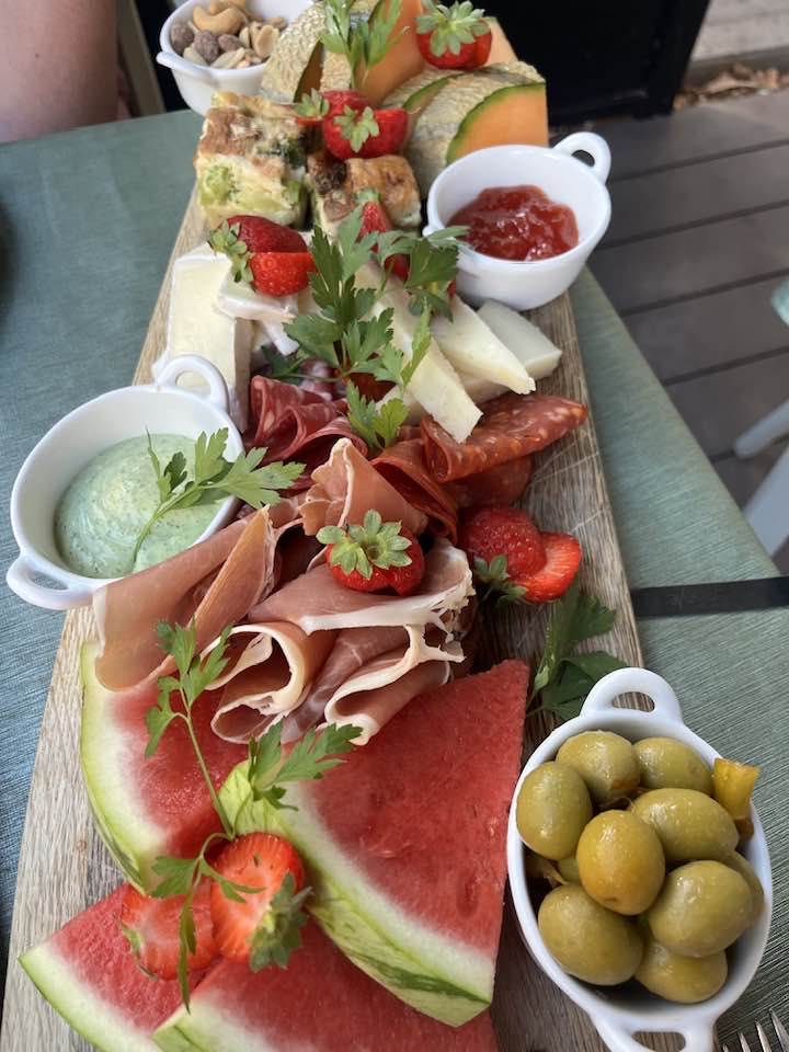 Veglegur bakki með vatnsmelónum, jarðarberjum, hráskinku og öðru þurrkuðu kjöti, ostum, ólífum og fleiru.