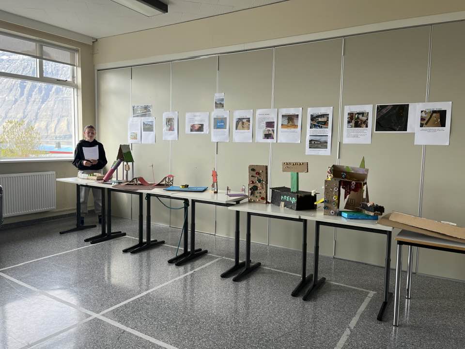 Nemandi við Grunnskóla Önundarfjarðar segir frá hugmynd sinni. Á röð borða má sjá skúlptúra sem nemendur hafa búið til.