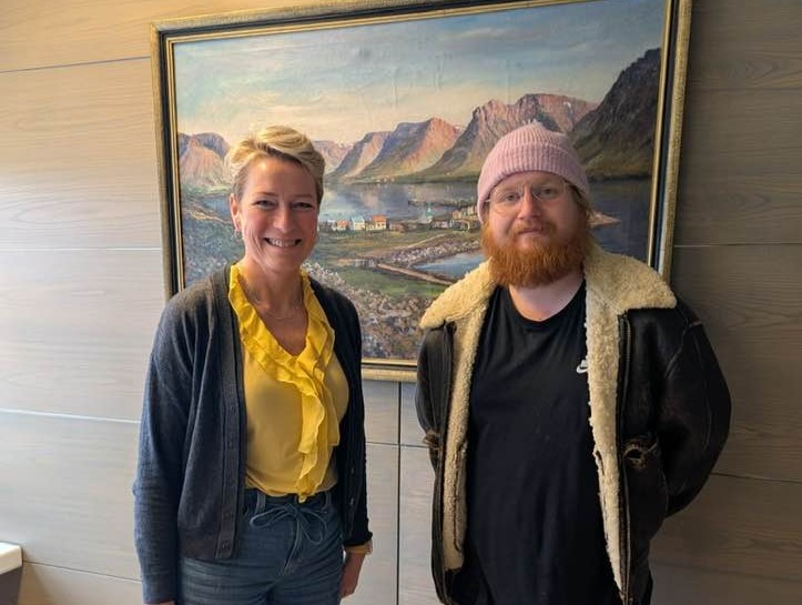 Sigga með Úlfi frá hollvinasamtökunum, inni á skrifstofu bæjarstjóra fyrir framan stórt málverk af Flateyri.