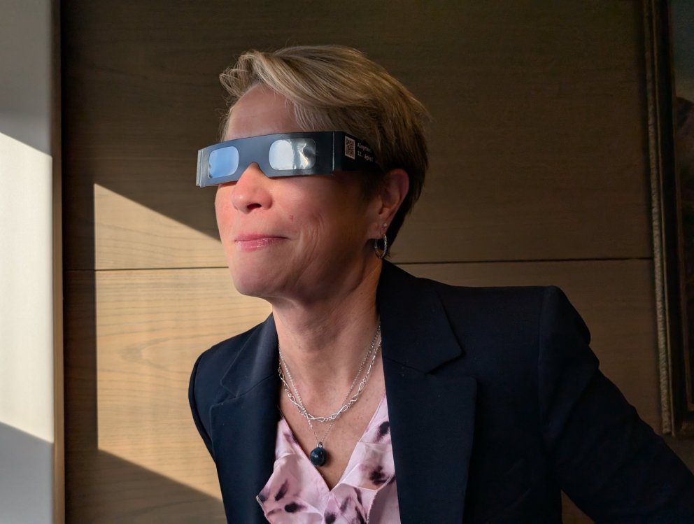 Sigríður Júlía bæjarstjóri prófar sólmyrkvagleraugun.