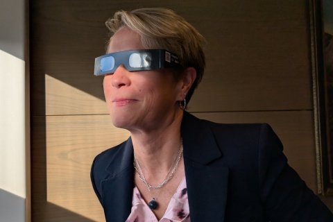 Sigríður Júlía bæjarstjóri prófar sólmyrkvagleraugun.